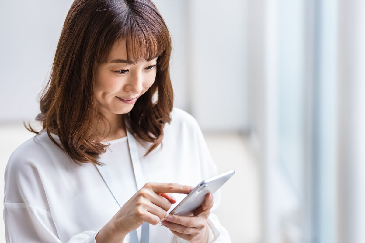 スマートフォンを触る女性の画像